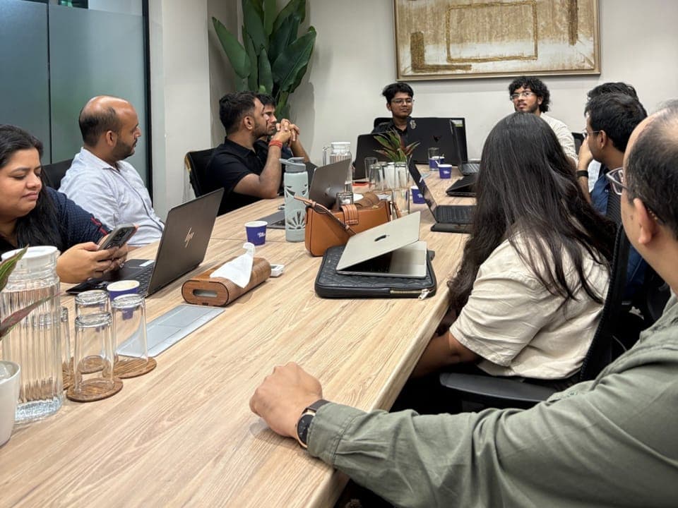 A session: members around a table with their laptops open, talking a topic through